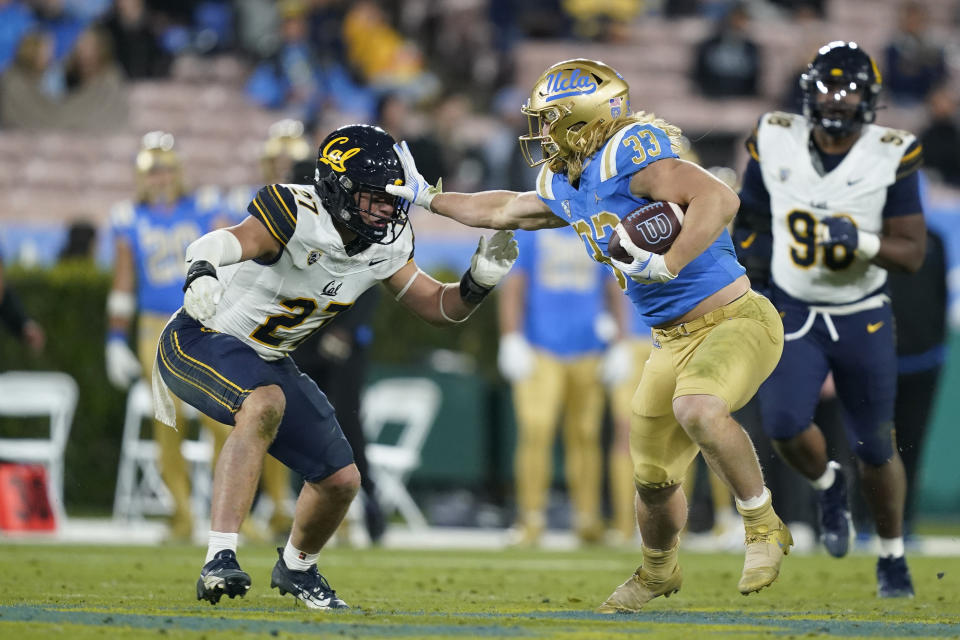 UCLA running back Carson Steele, right, stiff arms California linebacker Cade Uluave during the second half of an NCAA college football game, Saturday, Nov. 25, 2023, in Pasadena, Calif. (AP Photo/Ryan Sun)