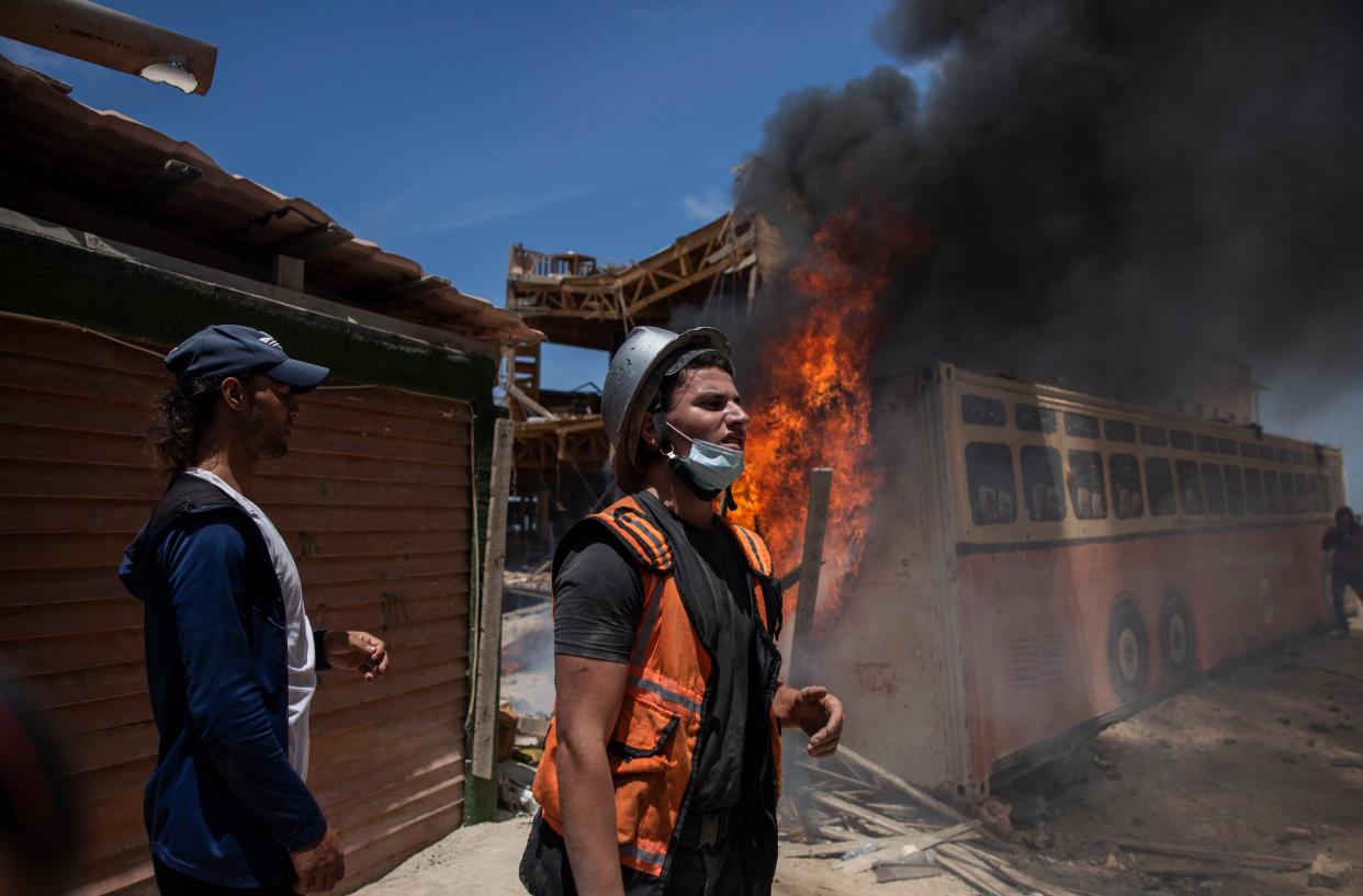 A Palestinian firefighter works at the site of a fire at a beachside cafe after it was hit by an Israeli airstrike, in Gaza City, Monday, May 17, 2021. 