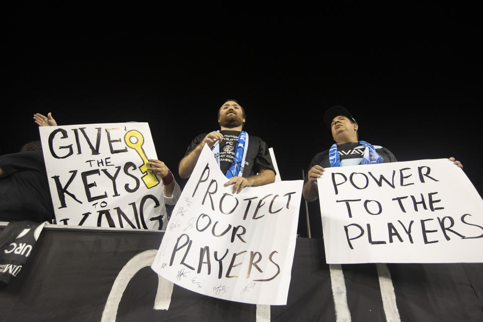 Fans hold signs in support of players, during an NWSL soccer match between NJ/NY Gotham FC and the Washington Spirit on Wednesday, Oct. 6, 2021, in Chester, Pa. (Charles Fox/The Philadelphia Inquirer via AP)