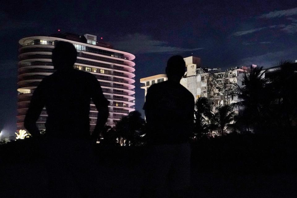 People view a partially collapsed building early Thursday, June 24, 2021, in the Surfside area of Miami, Fla.