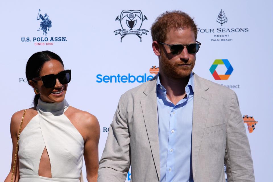 FILE - Britain's Prince Harry, right, and wife Meghan Markle, Duchess of Sussex, arrive for the 2024 Royal Salute Polo Challenge to Benefit Sentebale, on April 12, 2024, in Wellington, Fla. Prince Harry’s fight for police protection in the U.K. has received another setback. A judge on Monday, April 15, 2024 rejected his request to appeal an earlier ruling upholding a government panel’s decision to limit his access to publicly funded security after he quit as a working member of the royal family. (AP Photo/Rebecca Blackwell, File)
