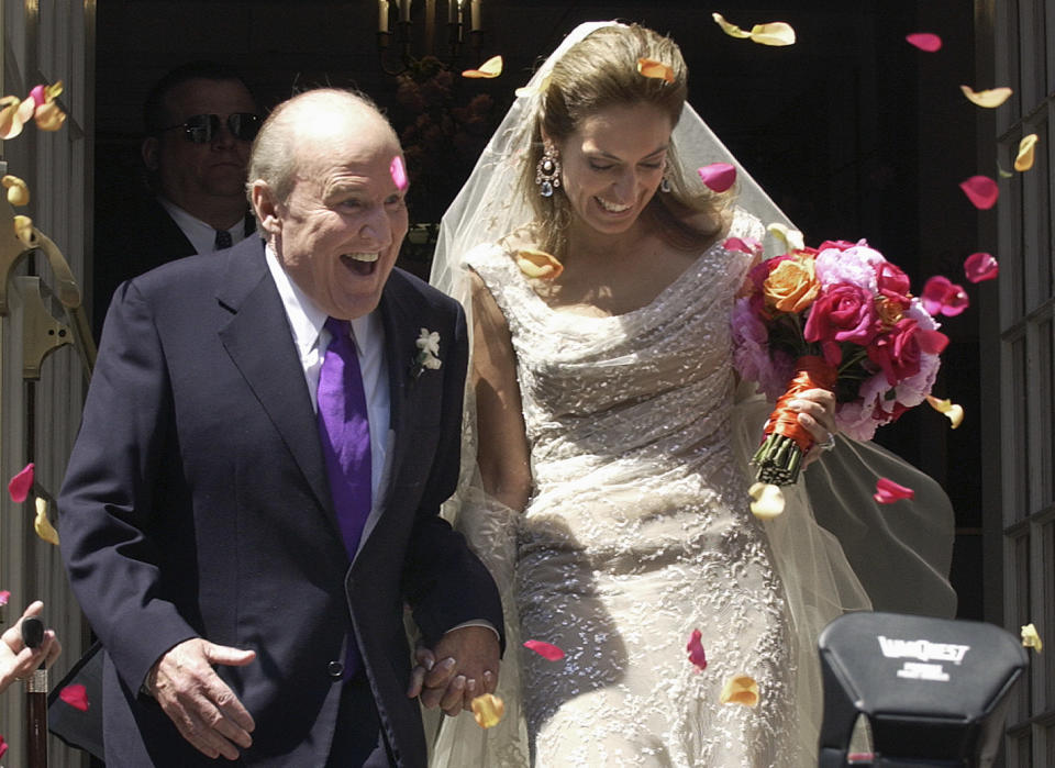 Former CEO of General Electric, Jack Welch (L), walks down the steps of Park Street Church with Suzy Wetlaufer after their wedding in Boston, Massachusetts, April 24, 2004. The couple met in October, 2001, while Wetlaufer was working on a story about Welch for the Harvard Business Review. REUTERS/Michael Dwyer  MAD/HB