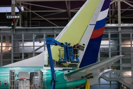 FILE PHOTO: Boeing employees work on the tail of a Boeing 737 NG at the Boeing plant in Renton, Washington