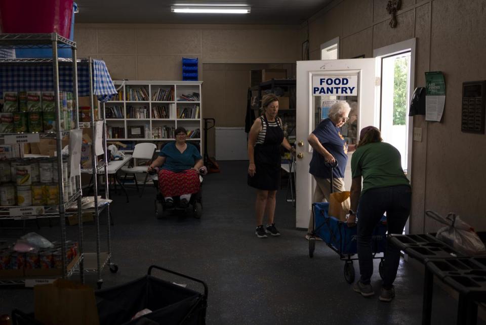 Volunteers and employees at the Leon Community Food Pantry and Clothes Closet in Jewett work together to cart food to a client on June 29, 2023. The grandfather of Kristy Vandergriff, pantry director, is the property owner of a part of the NRG Jewett Mine.