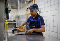 A staff member packs a pizza at a Domino's restaurant in Noida