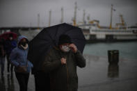 Commuters arrive to Karakoy ferry terminal in Istanbul, Turkey, Wednesday, Jan. 12, 2022. Turkey's government and central bank have taken a series of complex steps in recent weeks to prop up a beleaguered economy crippled by skyrocketing consumer prices, instead of ending a much-criticized plan to cut interest rates. (AP Photo/Francisco Seco)