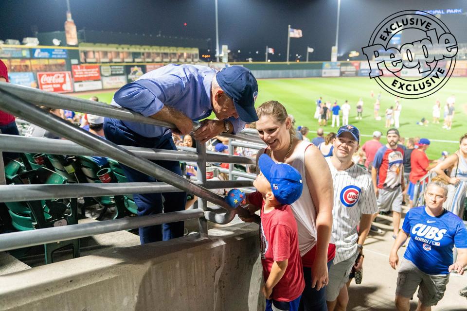 Biden talks with a young boy on the Fourth of July at the minor-league Iowa Cubs game after watching fireworks following a home team win.