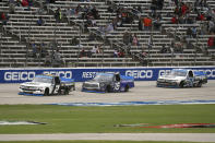 NASCAR Texas Trucks Series driver Sheldon Creed (2) tries to hold off Austin Hill (16) and Zane Smith (21) while going into the final lap during an auto race at Texas Motor Speedway in Fort Worth, Texas, Sunday, Oct. 25, 2020. (AP Photo/Richard W. Rodriguez)