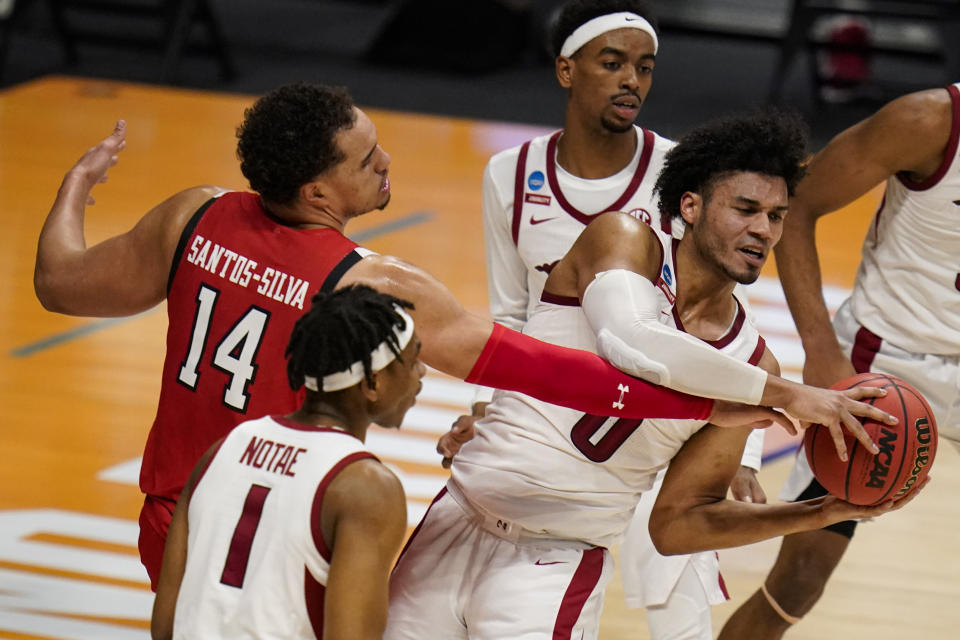 Arkansas forward Justin Smith (0) grabs a rebound from Texas Tech forward Marcus Santos-Silva (14) in the first half of a second-round game in the NCAA men's college basketball tournament at Hinkle Fieldhouse in Indianapolis, Sunday, March 21, 2021. (AP Photo/Michael Conroy)