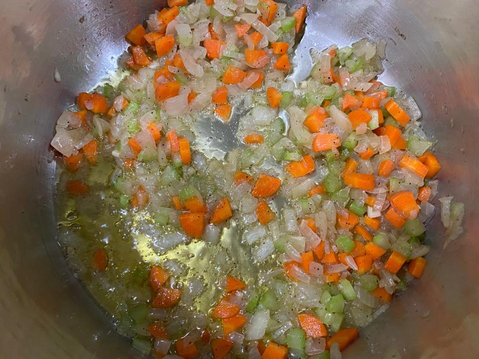 Sautéed diced carrots, onion, garlic, and celery in a pot