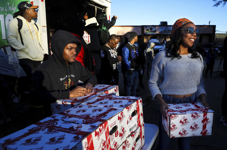 Gerica Robertson, right, helps pass out turkeys at St. James Missionary Baptist Church in south Memphis, Tenn., Friday, Nov. 19, 2021. The event was planned by local rapper Young Dolph before he was killed two days prior. (Patrick Lantrip/Daily Memphian via AP)