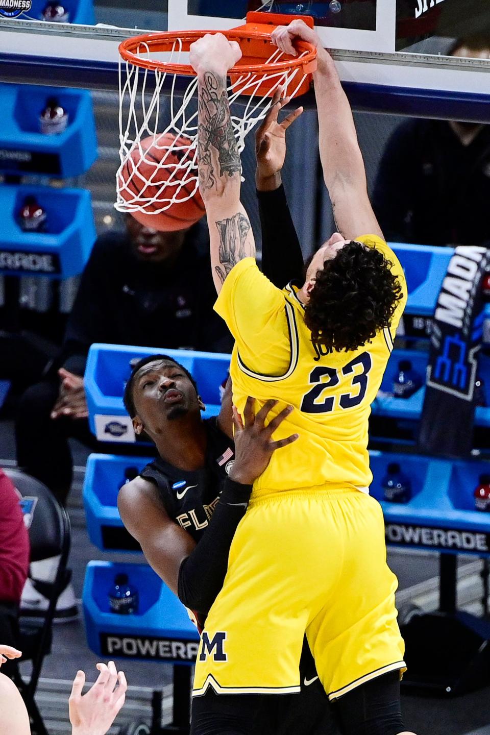 Michigan Wolverines forward Brandon Johns Jr. (23) dunks over Florida State Seminoles center Tanor Ngom (34) in the first half during the Sweet 16 of the 2021 NCAA tournament on March 28, 2021.