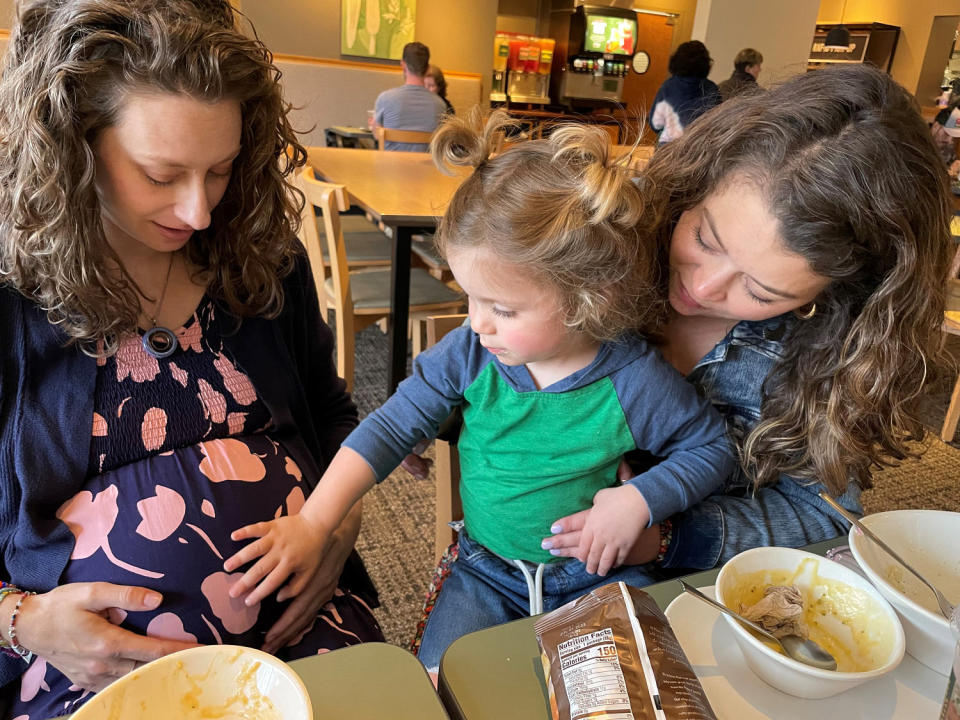 Alex Kamer's older son touches the pregnant belly of Zientek, who served as the surrogate for the new baby. (Courtesy Alex Kamer)