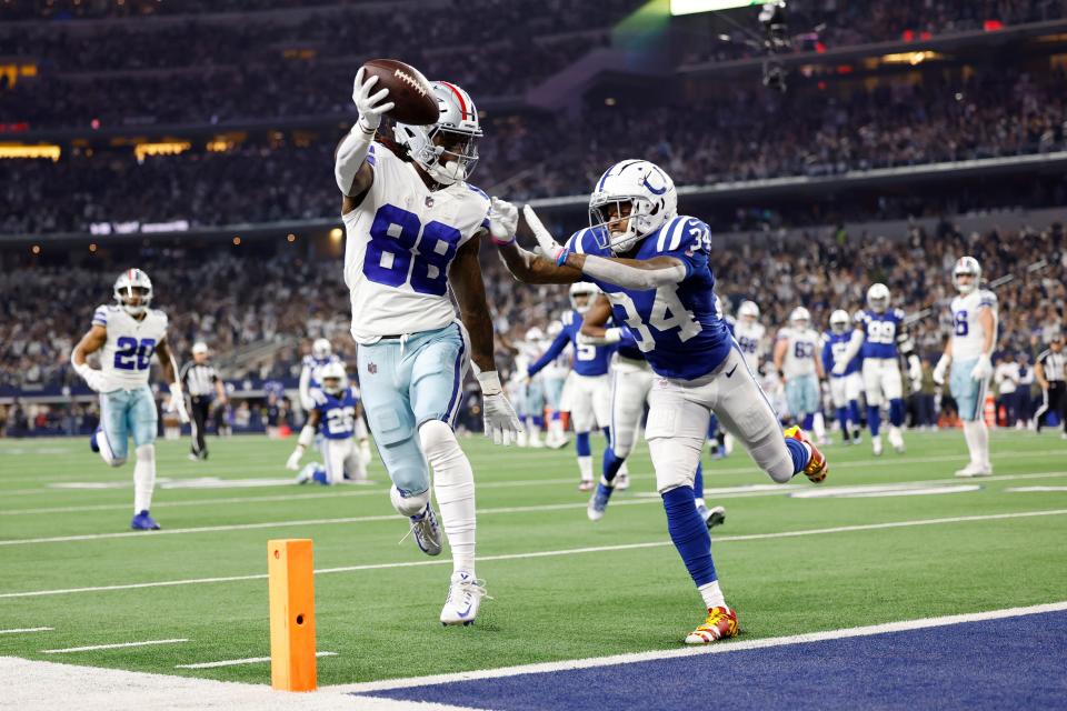 ARLINGTON, TEXAS - DECEMBER 04: CeeDee Lamb #88 of the Dallas Cowboys scores a touchdown as Isaiah Rodgers #34 of the Indianapolis Colts defends in the first quarter at AT&T Stadium on December 04, 2022 in Arlington, Texas.