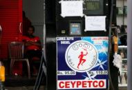 A worker rests at a closed Ceylon Petroleum fuel station near the highway entrance in Galle, Sri Lanka July 26, 2017. REUTERS/Dinuka Liyanawatte