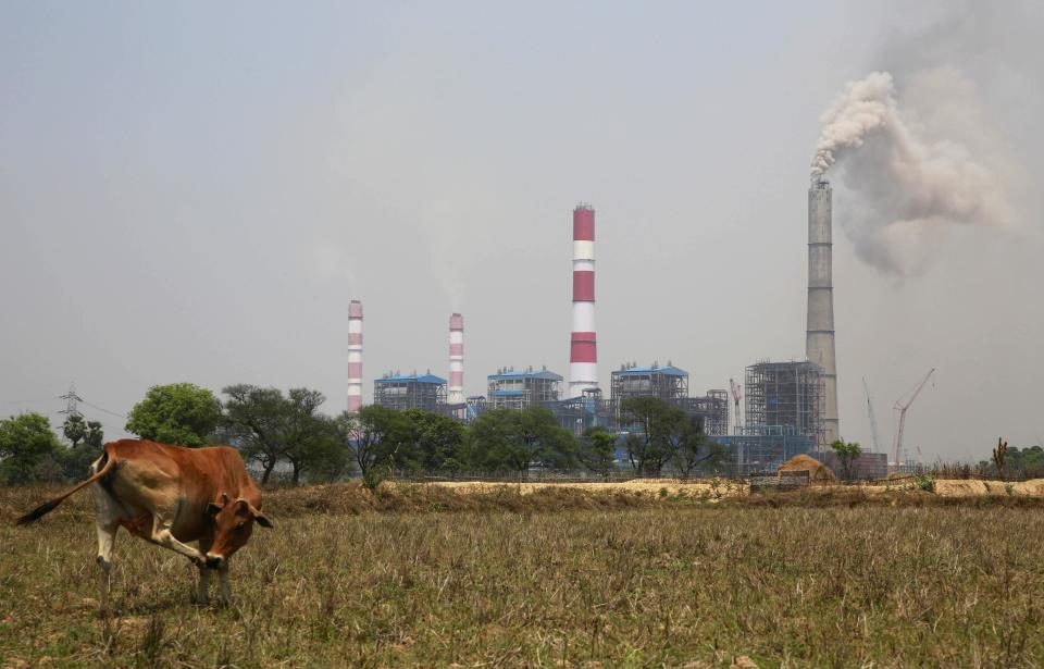 In this April 15, 2014 photo, smoke emits from an electricity plant owned by Jindal Steel & Power Ltd. that runs on coal gathered from open mines dug near villages in Tamnar, near the industrial city of Raigarh, Chhattisgarh state, India. The company has been mining coal in the area for several years. (AP Photo/Rafiq Maqbool)