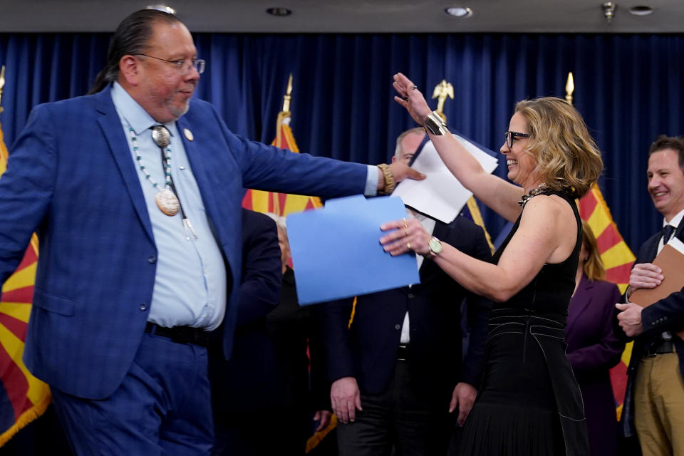 Gila River Indian Community Governor Stephen Roe Lewis, left, hugs U.S. Sen. Kyrsten Sinema, I-Ariz., at the Capitol, Thursday, April 6, 2023, in Phoenix. Lewis and Sinema were discussing newly announced water conservation funding for Gila River Indian Community and water users across the Colorado River Basin aimed to protect the stability and sustainability of the Colorado River System. (AP Photo/Matt York)