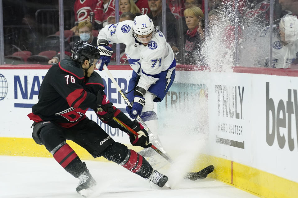 Carolina Hurricanes defenseman Brady Skjei (76) and Tampa Bay Lightning center Anthony Cirelli (71) chase the puck during the first period in Game 1 of an NHL hockey Stanley Cup second-round playoff series in Raleigh, N.C., Sunday, May 30, 2021. (AP Photo/Gerry Broome)