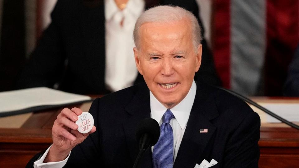 PHOTO: President Joe Biden holds up a Laken Riley button as he delivers the State of the Union address to a joint session of Congress at the U.S. Capitol, Mar. 7, 2024, in Washington.  (Andrew Harnik/AP)