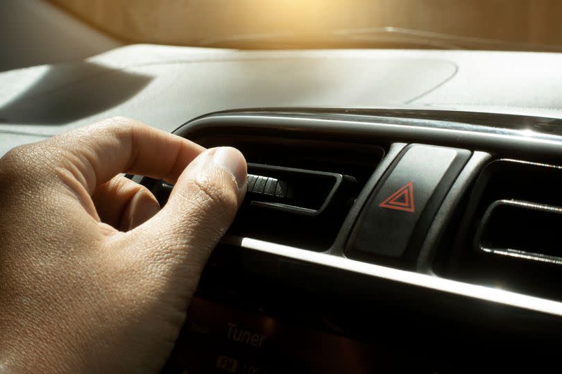 People's hand on adjusting Air condition in the car during summer time.