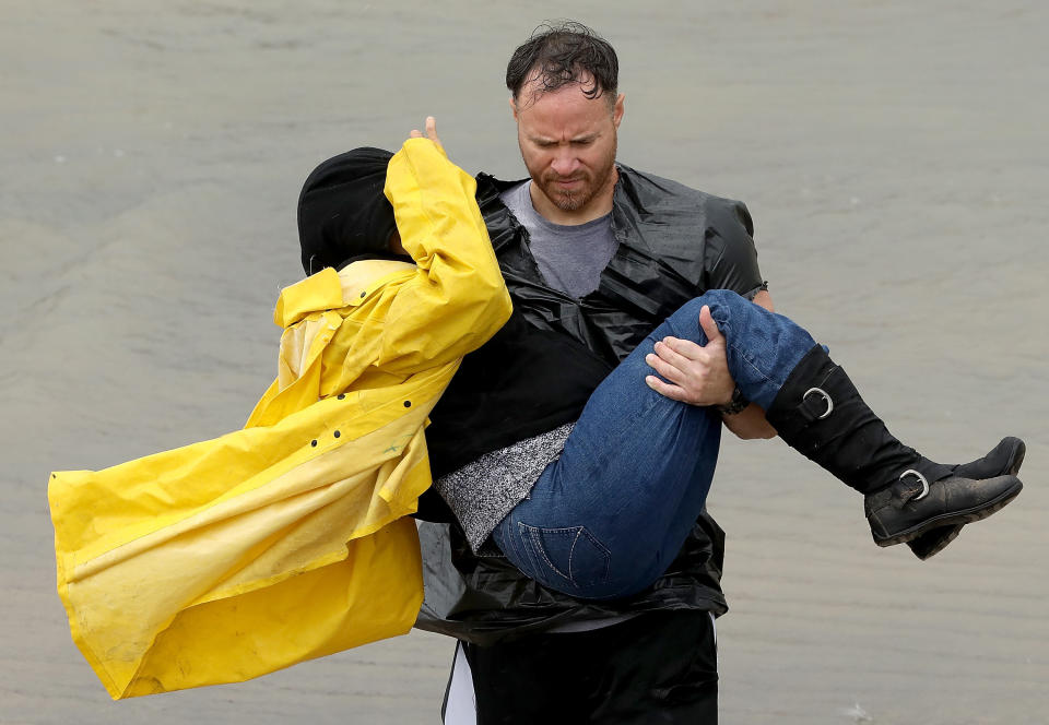 A volunteer carries a woman whose home was affected&nbsp;by severe flooding in north Houston.