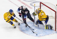 Sweden goalie Jesper Wallstedt (1) makes a save on United States' Landon Slaggert (26) as Victor Soderstrom (8) defends during the second period of an IIHF World Junior Hockey Championship game Thursday, Dec. 31, 2020, in Edmonton, Alberta. (Jason Franson/The Canadian Press via AP)