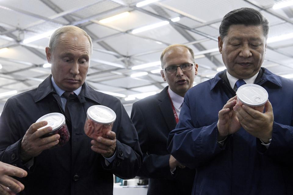 Chinese President Xi Jinping, right, and Russian President Vladimir Putin look at containers of food as they visit an exhibition during the Eastern Economic Forum in Vladivostok, Russia, Tuesday, Sept. 11, 2018. (Kirill Kudryavtsev Photo via AP)