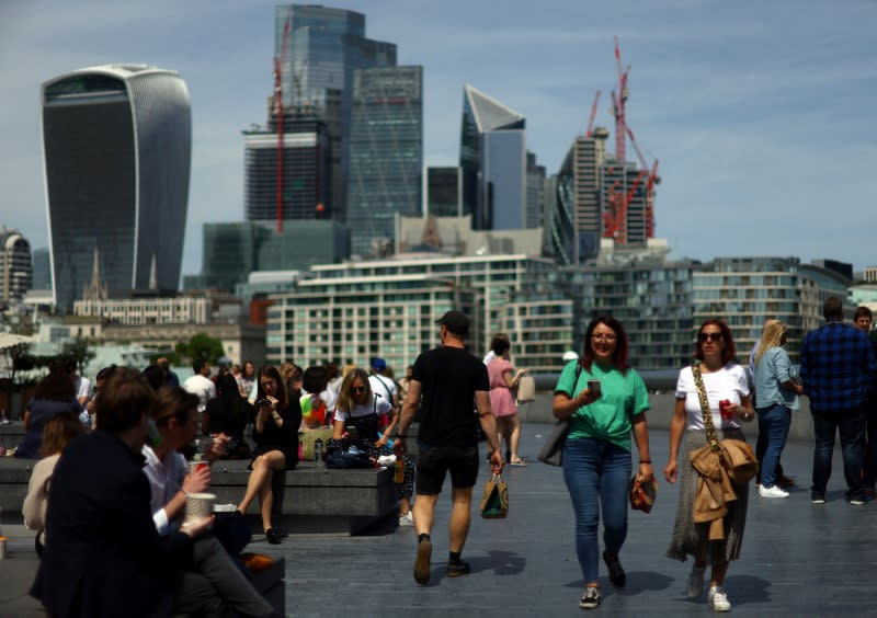 FOTO DE ARCHIVO: La gente disfruta del clima cálido frente al distrito financiero de la ciudad de Londres