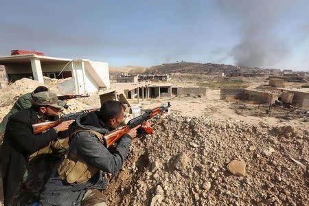 Members of the Kurdish peshmerga forces take positions with their weapons in the town of Sinjar, Iraq November 12, 2015. REUTERS/Ari Jalal