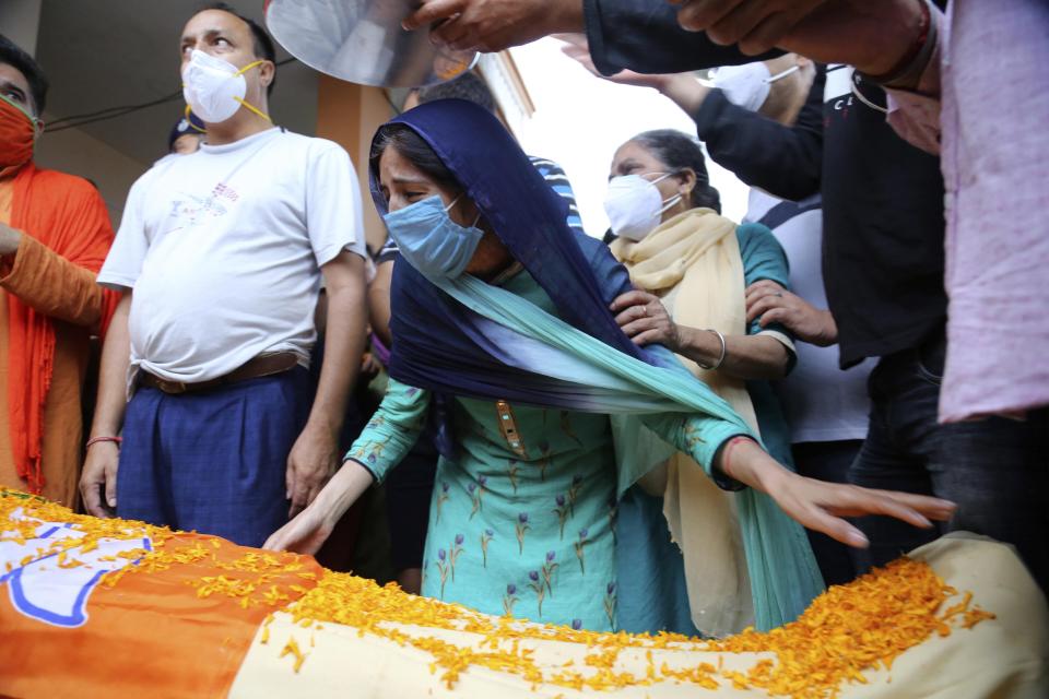 The wife of Rakesh Pandita, a politician who was killed late Wednesday, mourns at their residence in Jammu, India, Thursday, June.3, 2021. Assailants fatally shot the politician belonging to India’s ruling party in disputed Kashmir, police said Thursday, blaming separatist rebels for the attack. The unidentified assailants fired at Pandita late Wednesday in the southern town of Tral, where he was visiting a friend, police said. He was declared dead in a hospital. (AP Photo/Channi Anand)