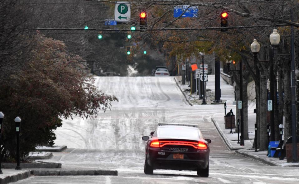 A police car with the Wilmington Police Department heads up Market St. in Wilmington, N.C., Saturday Jan. 22, 2022. A wintry mix fell throughout the night over the Wilmington area and created dangerous conditions.   [MATT BORN/STARNEWS]