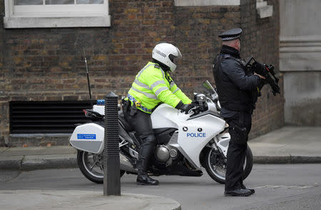 An armed police officer and police motorcycle outrider stand on duty in Downing Street, London, Britain December 6, 2017. REUTERS/Toby Melville