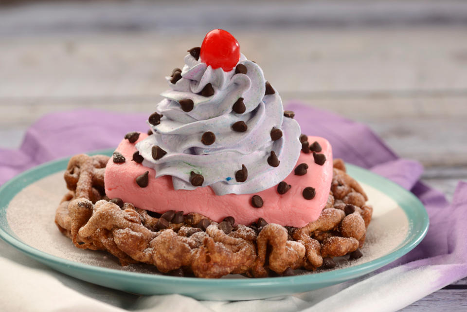 <p>No trip to Epcot is complete with a trip to Funnel Cake, at the American Adventure. They've got a new cherry blossom funnel cake that looks incredible. It's a chocolate chip funnel cake, topped with cherry ice cream, rainbow whipped cream, chocolate chips, and a Maraschino cherry. <strong><br></strong></p>