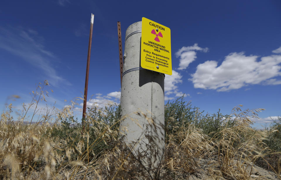 FILE - In this July 11, 2016 file photo, a sign warns of radioactive material stored underground on the Hanford Nuclear Reservation near Richland, Wash. Conservation groups are alarmed by the Trump administration's proposal to rename some radioactive waste left from the production of nuclear weapons to make it cheaper and easier to achieve permanent disposal. The U.S. Department of Energy is considering a change in its legal definition of high-level radioactive waste, which is stored at places like the Hanford. (AP Photo/Ted S. Warren, File)