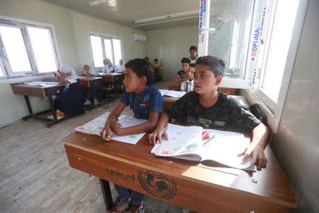 Children of Iraqi Kawliya group (known as Iraqi gypsies) attend a class at a school in al-Zuhoor village near the southern city of Diwaniya, Iraq April 16, 2018. Picture taken April 16, 2018. REUTERS/Alaa Al-Marjani