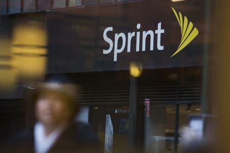 People walk past a Sprint store in New York December 17, 2012. Sprint Corp reported higher-than-expected first-quarter revenue on July 30, 2014, as the company expanded its high-speed coverage and came closer to completing a network upgrade that had caused a massive drop in customers. REUTERS/Andrew Kelly/Files