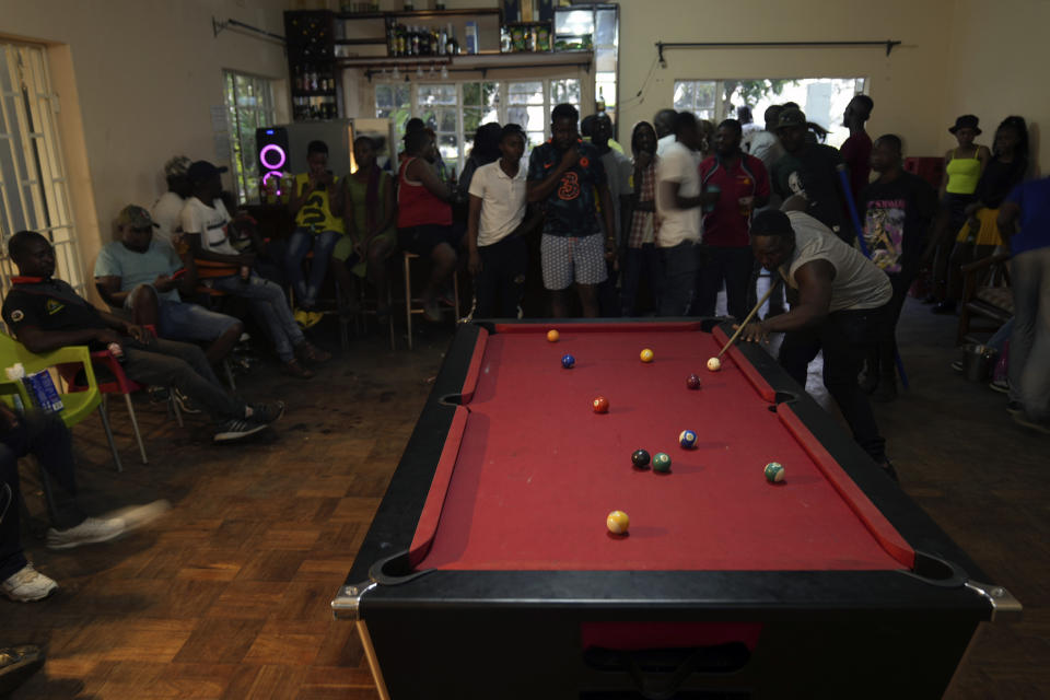 People play pool in a bar on the outskirts of Harare, Zimbabwe, Saturday, Nov. 19, 2022. Previously a minority and elite sport in Zimbabwe, the game has increased in popularity over the years, first as a pastime and now as a survival mode for many in a country where employment is hard to come by. (AP Photo/Tsvangirayi Mukwazhi)