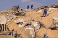 In this photo taken from footage provided by the Russian Emergency Situations Ministry press service, Russian Emergency Situations personnel walk on the site of the explosion in the port of Beirut, Lebanon, on Thursday, Aug. 6, 2020. Russia's emergency officials say the country sent five planeloads of aid to Beirut after an explosion in the Lebanese capital's port killed at least 100 people and injured thousands on Tuesday. Russia's Ministry for Emergency Situations sent rescuers, medical workers, a makeshift hospital and a lab for coronavirus testing to Lebanon. (AP Photo/Ministry of Emergency Situations press service via AP)