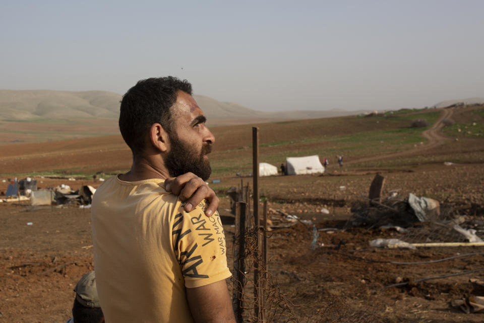 A Palestinian Bedouin rests while rebuilding an animal pen after Israeli troops demolished tents and other structures of the Khirbet Humsu hamlet in the Jordan Valley in the West Bank, Wednesday, Feb. 3, 2021. A battle of wills is underway in the occupied West Bank, where Israel has demolished the herding community of Khirbet Humsu three times in as many months, displacing dozens of Palestinians. Each time they have returned and tried to rebuild, saying they have nowhere else to go. (AP Photo/Maya Alleruzzo)