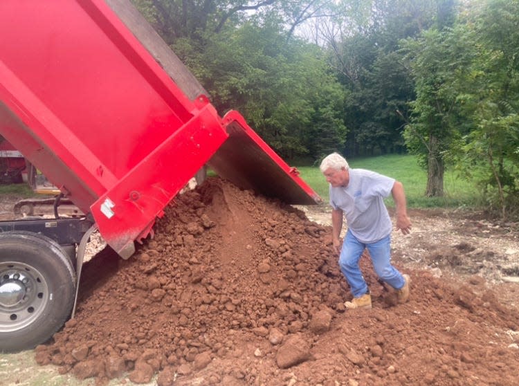 Bob Lilick, of BRB Contractors, Pottstown, directs a dump truck placing topsoil at the site of razed "Cuckold Tavern," at Route 413 and Bridgetown Pike in Middletown on Thursday Aug. 24, 2023. The building dated to the 18th century, was owned by Bucks County, but could not be preserved due to flooding on the property.