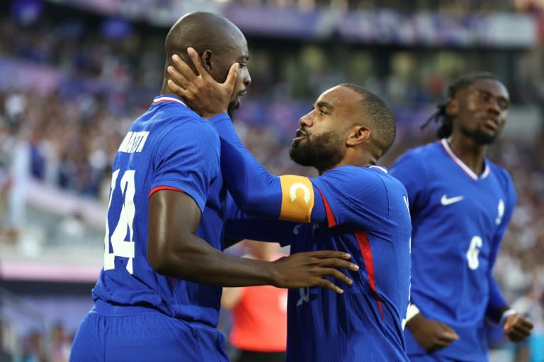 El delantero de Francia Jean-Philippe Mateta (I) celebra con el capitán, Alexandre Lacazette, después de marcar el primer gol de su equipo contra Argentina, en el partido de fútbol masculino de cuartos de final de los Juegos Olímpicos de París 2024, en el estadio de Burdeos, el 2 de agosto de 2024. (ROMAIN PERROCHEAU)