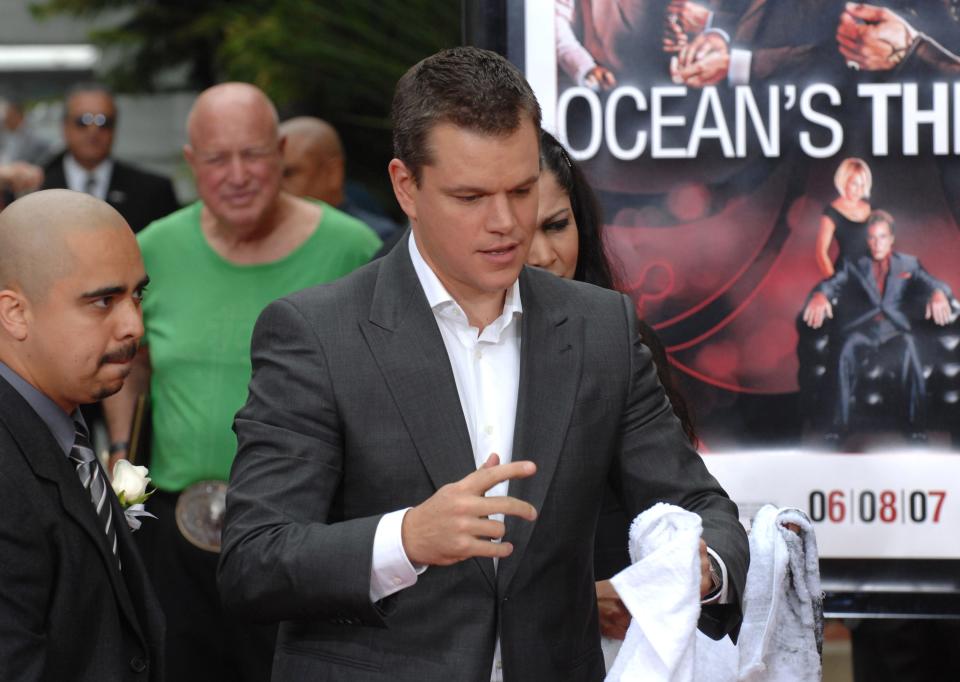Matt Damon in front of an Ocean's Thirteen poster