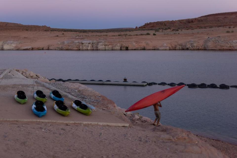 A kayaker climbs down the drop-off below the Antelope Point boat launch ramp which was made unusable by record low water levels.