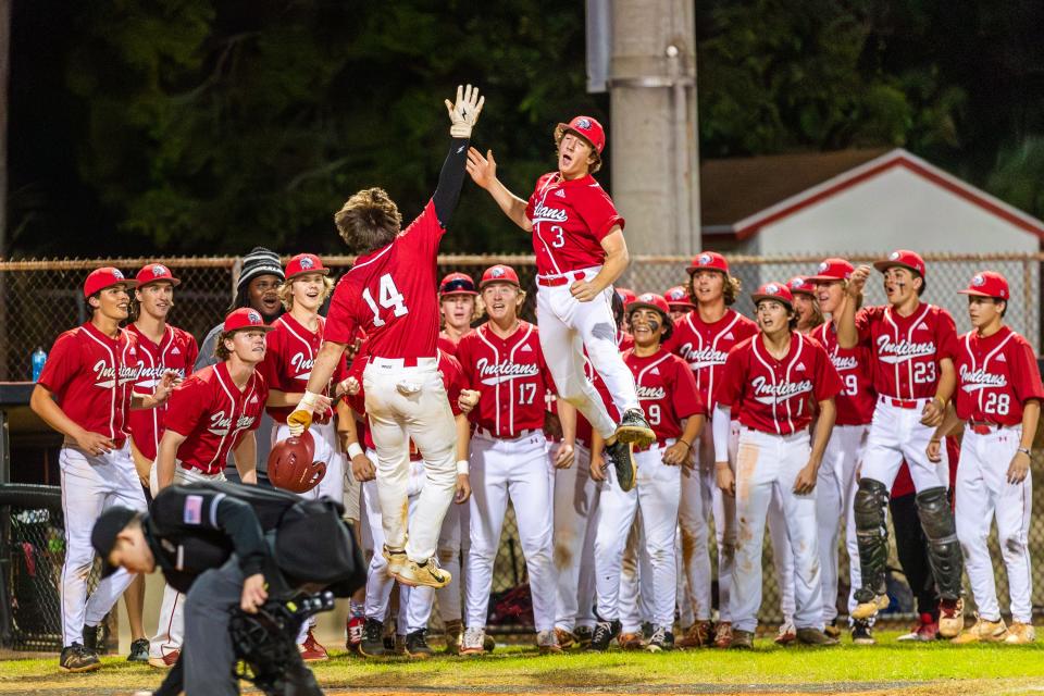 Cole Morgan (14), high fives a teammate after hitting a solo home run against St. Lucie West Centennial in a high school baseball game at Vero Beach, Friday, Feb. 23, 2024.