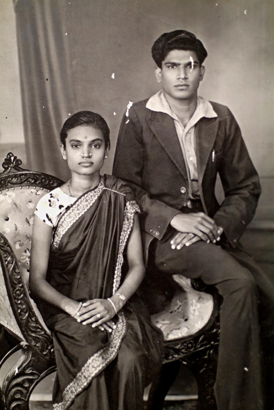 Two Chettians sit in a chair posing for a family photograph.