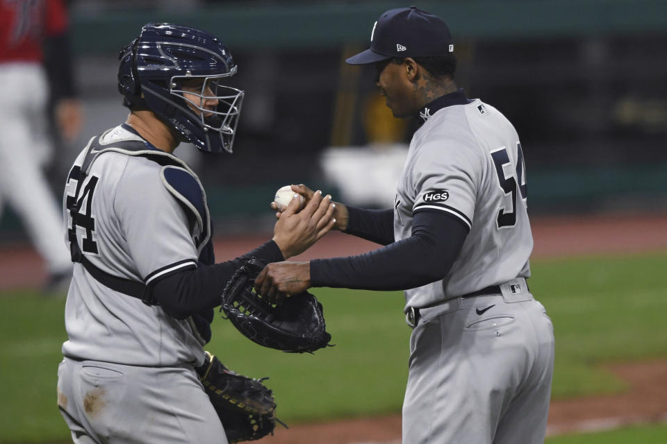 New York Yankees relief pitcher Aroldis Chapman (54) is congratulated by catcher Gary Sanchez after the Yankees defeated the Cleveland Indians 10-9 in Game 2 of an American League wild-card baseball series, early Thursday, Oct. 1, 2020, in Cleveland. (AP Photo/David Dermer)