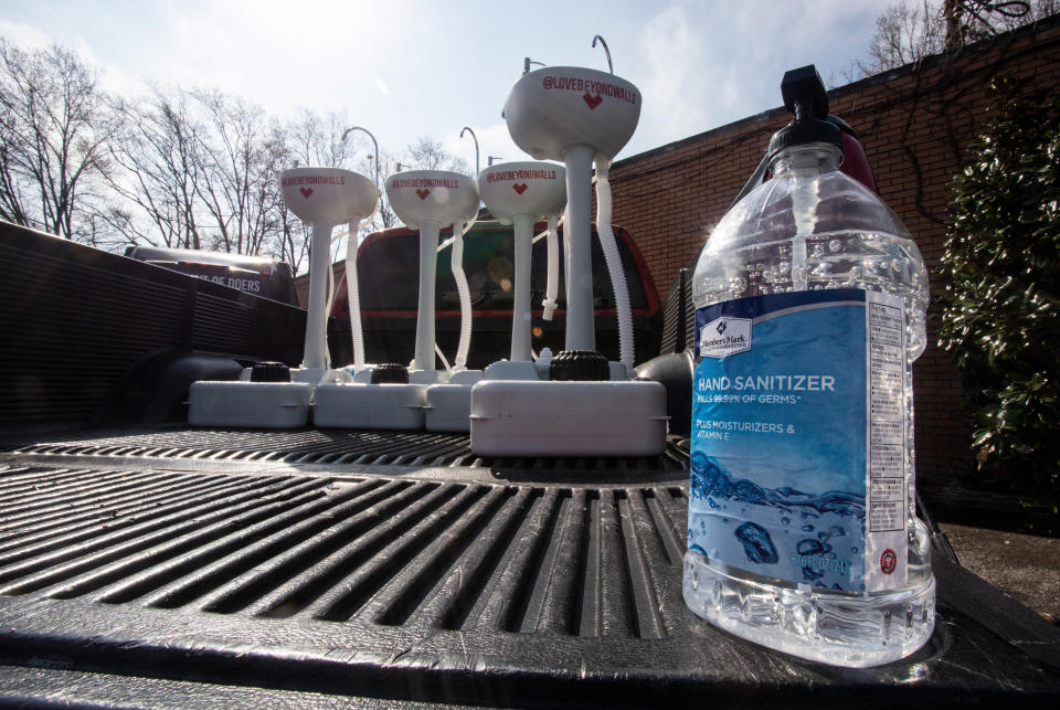 Hand sanitizer and portable wash stations rest on a truck bed on Thursday, March 19, 2020 in College Park, Georgia. The wash stations were distributed by hip hop recording artist Lecrae and volunteers with Love Beyond Walls, a non-profit, throughout Atlanta in areas with a high density of homeless persons. (AP Photo/ Ron Harris)