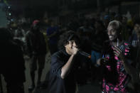 AXN sings at the Gas Battle rapping competition outside a bar in the City of God favela of Rio de Janeiro, Brazil, late Wednesday, Nov. 10, 2021. Rap artists in the favela are starting to compete again since the COVID-19 pandemic curtailed public gatherings, presenting local residents with a show in a sign of a return to normalcy for music lovers. (AP Photo/Silvia Izquierdo)