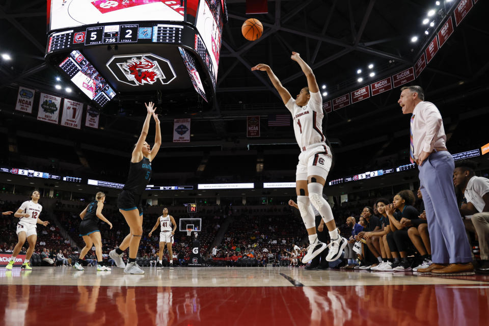 South Carolina guard Zia Cooke (1) shoots a three-pointer against Coastal Carolina guard Deaja Richardson (5) as Coastal Carolina head coach Kevin Pederson, right, looks on during the first half of an NCAA college basketball game in Columbia, S.C., Wednesday, Dec. 21, 2022. (AP Photo/Nell Redmond)