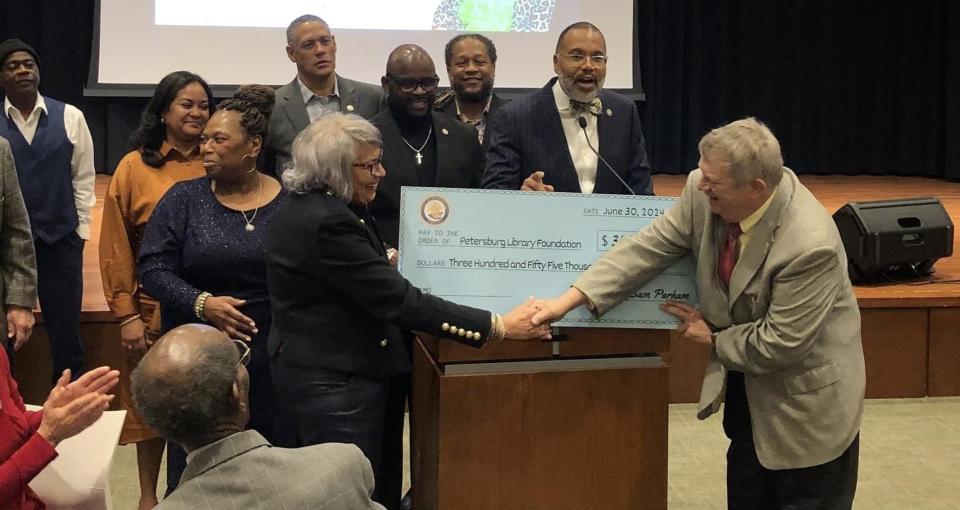 Bob Walker, Petersburg Library Foundation Board of Directors President, shakes hands with Ann Taylor during a $355,000 check presentation at the library's Event Center on January 6.